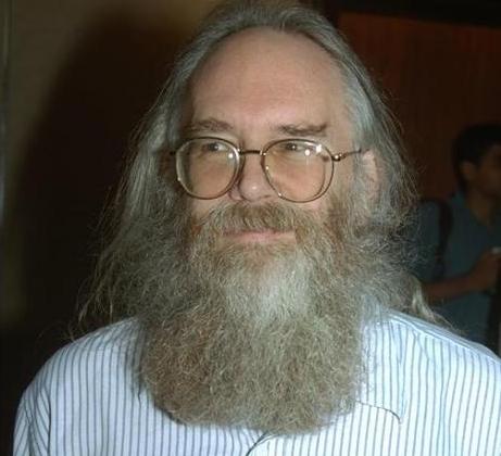 a man with a long grey beard wearing glasses smiling