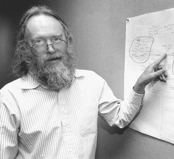 a black and white photo of a man wearing glasses looking at camera while pointing on a whiteboard”></a>After the death of Jon Postel, the Internet Society establishes the <a href=