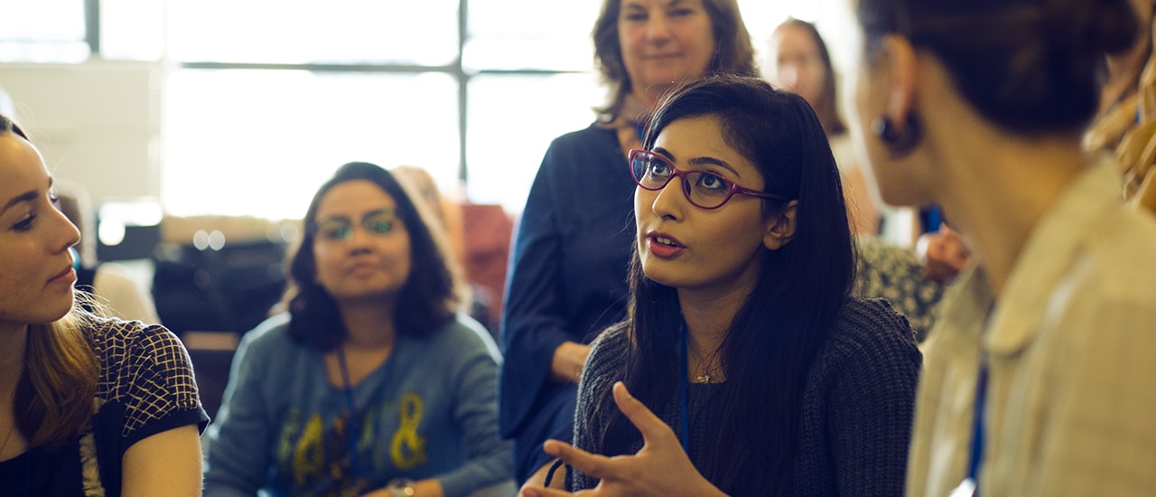 a woman explaining something to a group of women