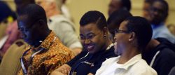 two women sitting in a conference room, talking and smiling