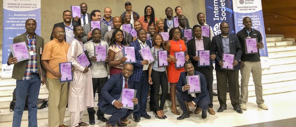 Un groupe de personnes posant pour une photo et tenant des papiers violets