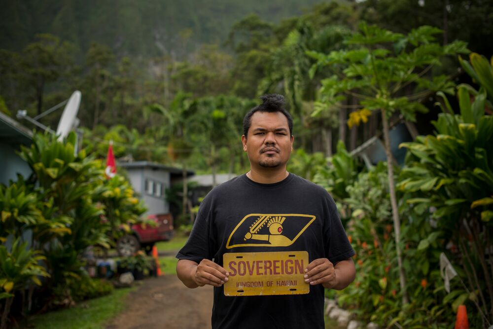 A man standing and holding a sign with Sovereign written on it