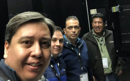 Four men posing in a datacentre