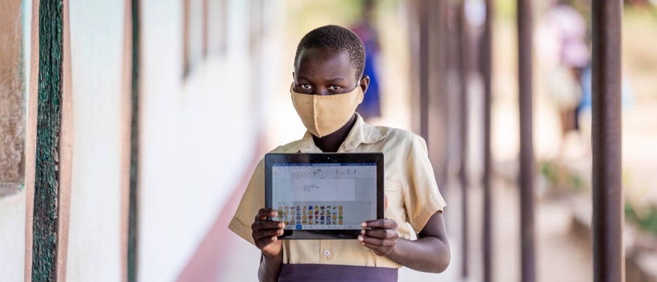 Enfant portant un masque et tenant une tablette