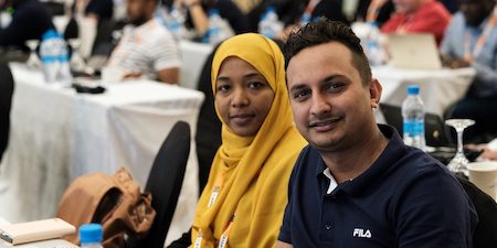 Un homme et une femme assis à la table lors d’une conférence