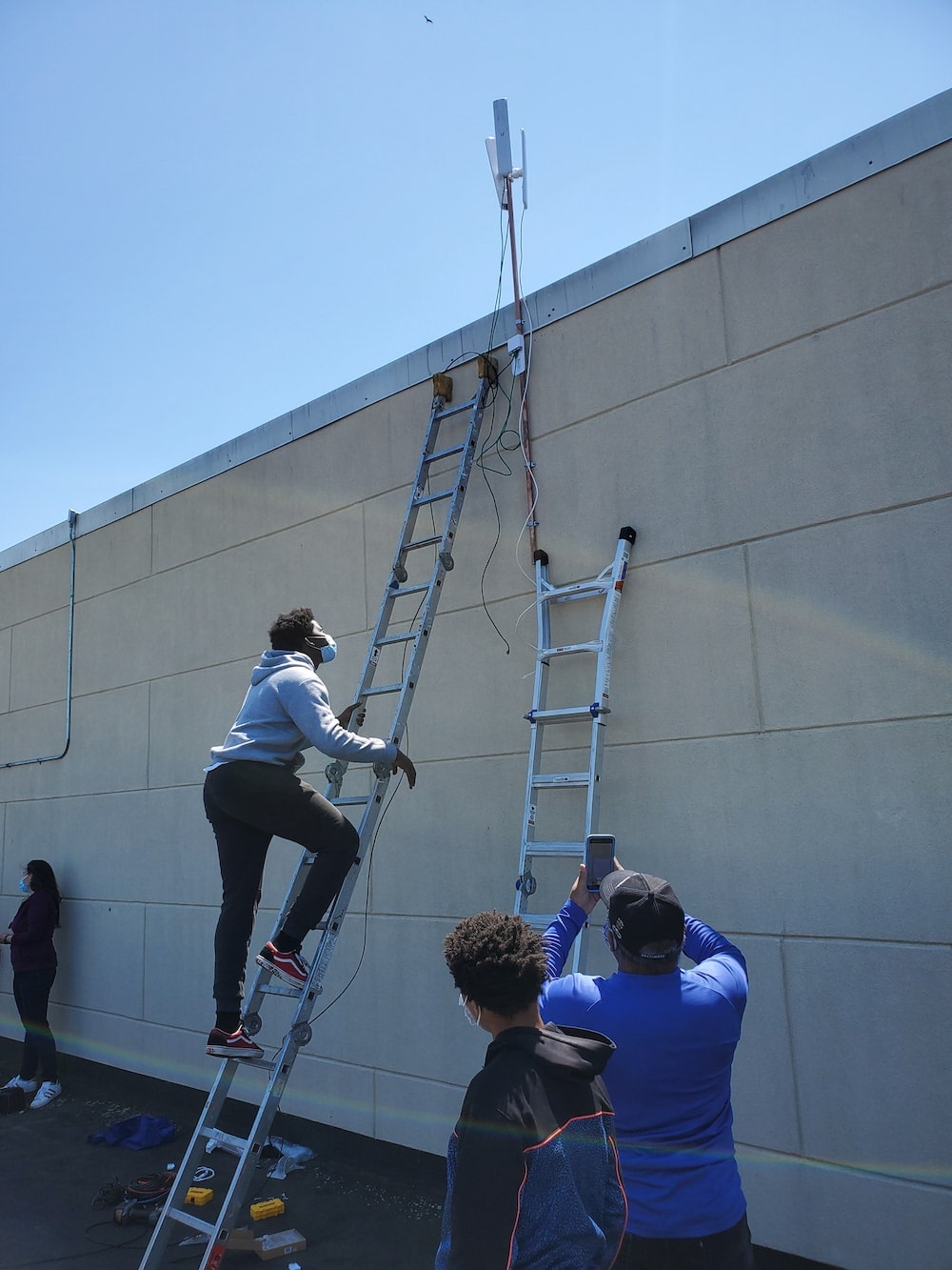A man with face mask climbing the ladder
