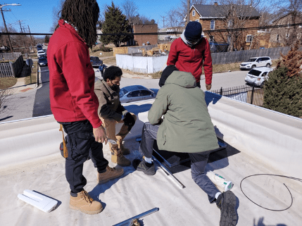 Four men on the roof installing equipment 