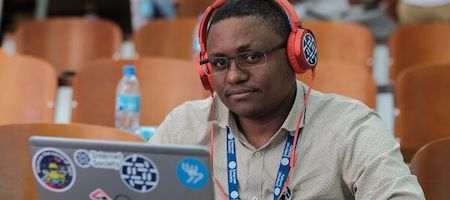 A person with headphones sitting in front of laptop