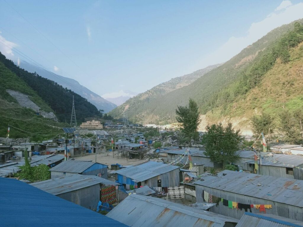 makeshift corrugated tin shelters between mountains