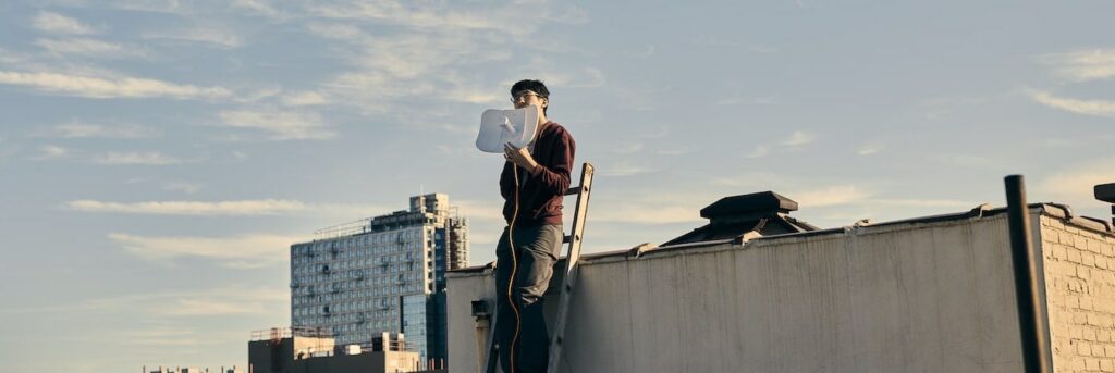 a man holding an antenna on ladder