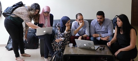 a group of people looking at laptops
