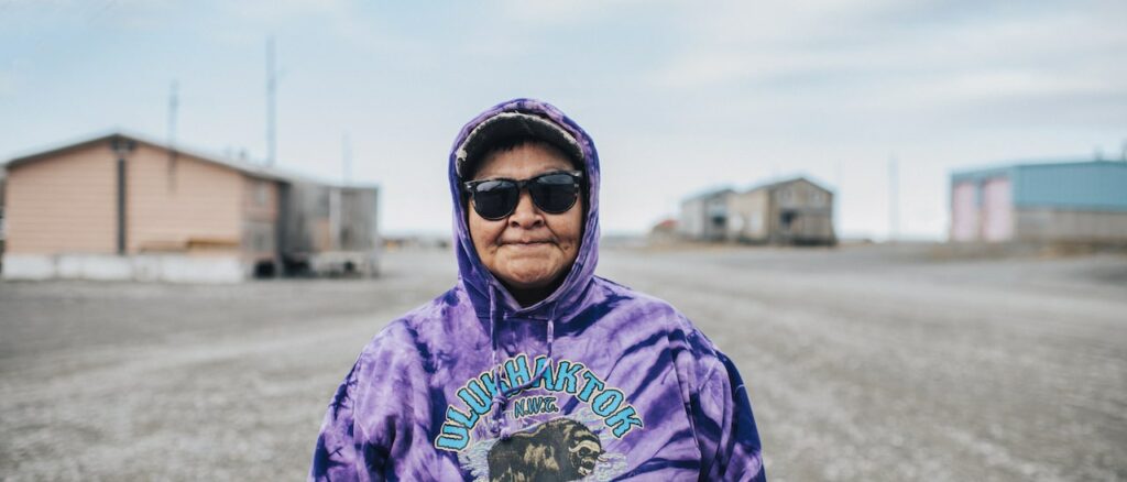 an indigenous woman wearing sunglasses looking at camera