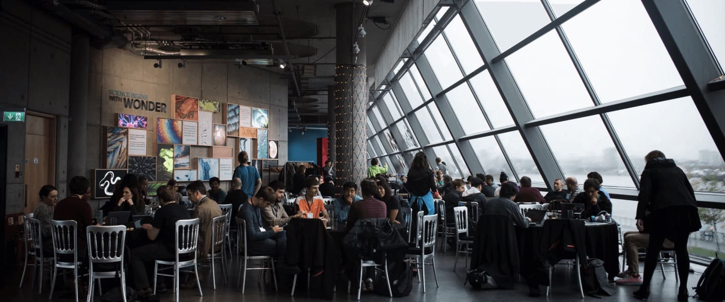 a group of people sitting at tables talking