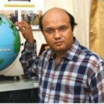 A picture of Vashkar Bhattacharjee touching a globe