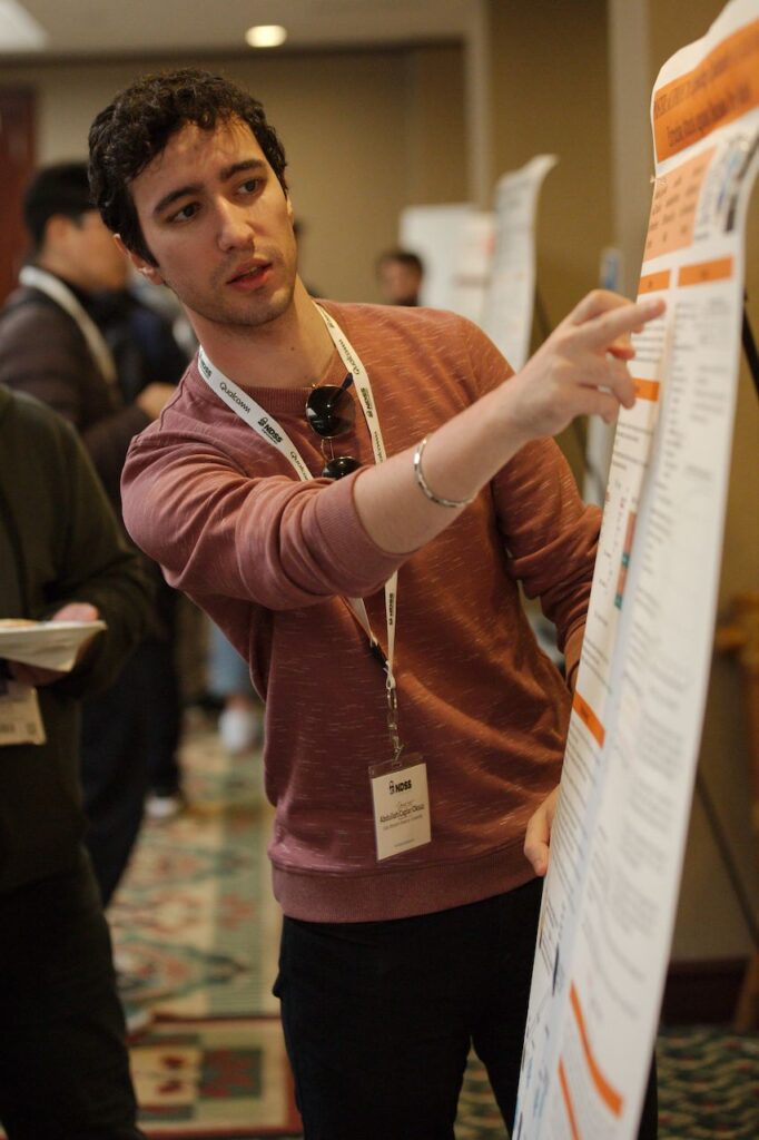 a man pointing at a whiteboard explaining