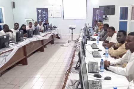 a group of people at desks in front of computer