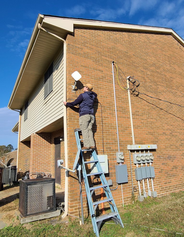 un homme sur une échelle installant une antenne