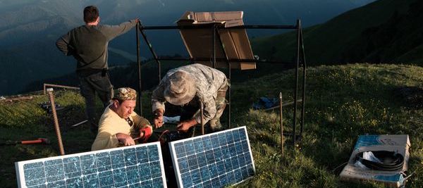 deux hommes travaillant sur un panneau solaire