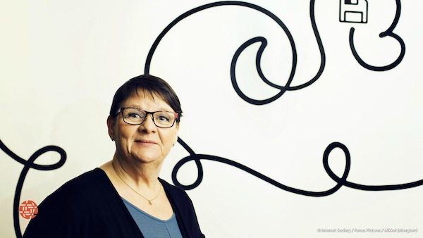 a woman with glasses in front of the wall