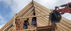 two men working on a roof construction