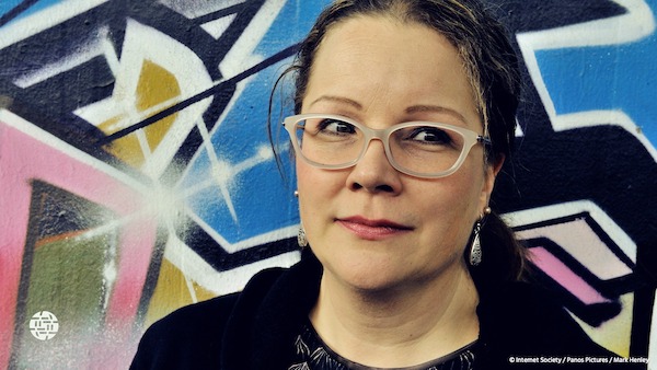 a woman with glasses in front of the wall