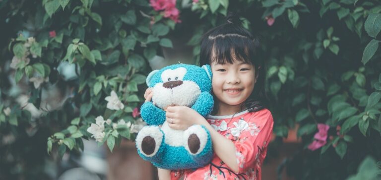 a little girl holding teddy bear