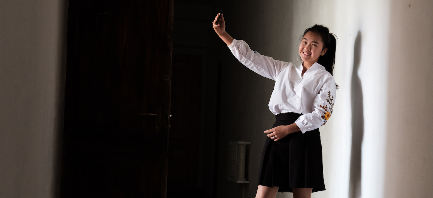 a school girl posing for a selfie in the school corridor