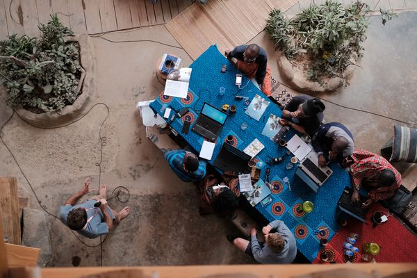 People sitting at the table with laptops photographed from above