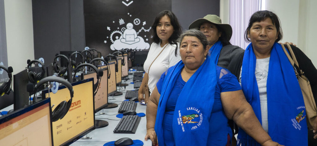 four woman next to the computers posing for a photo