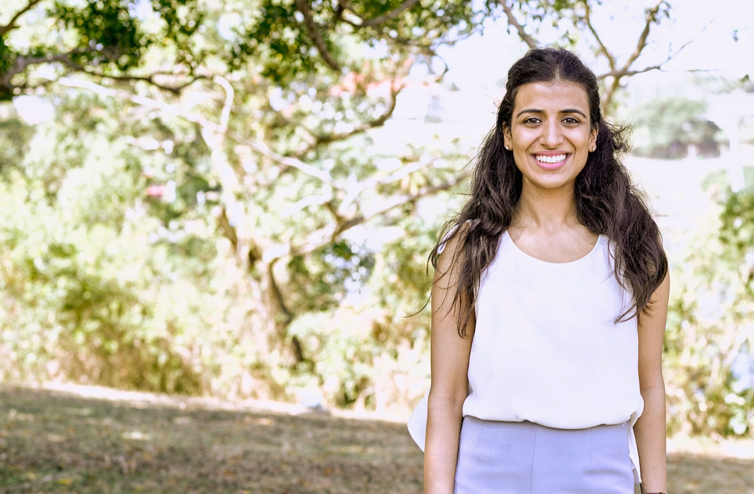 una chica con el pelo largo sonriendo mientras posa para una foto al aire libre