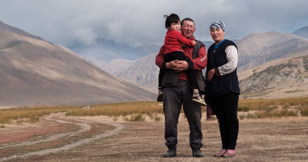 woman and a man holding a child posing for a photo outdoors