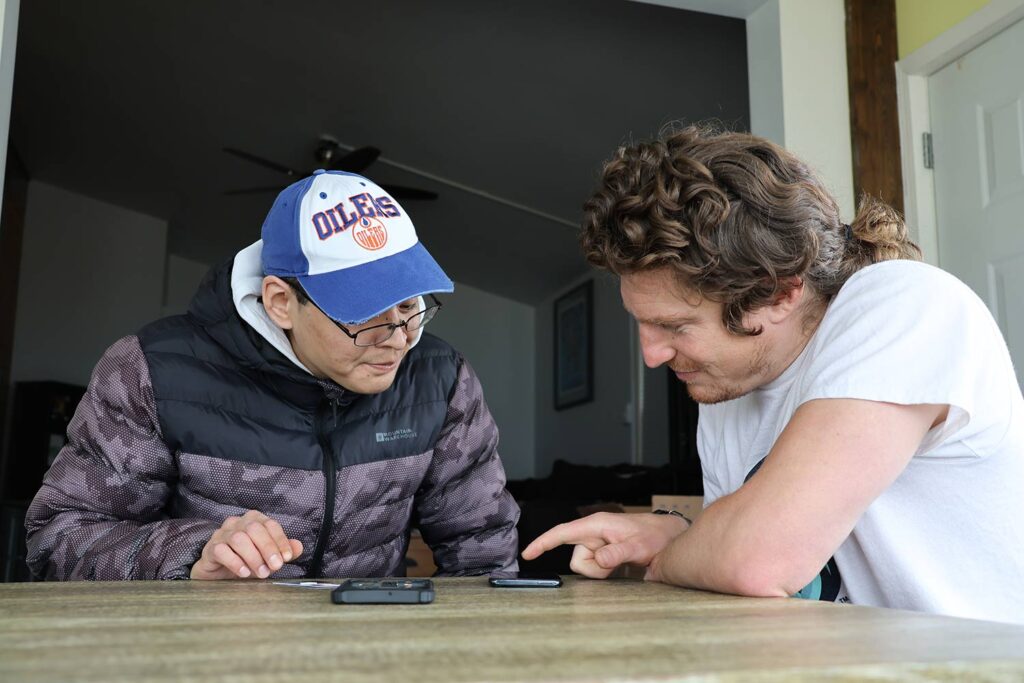 deux personnes regardant l'écran d'un téléphone portable 