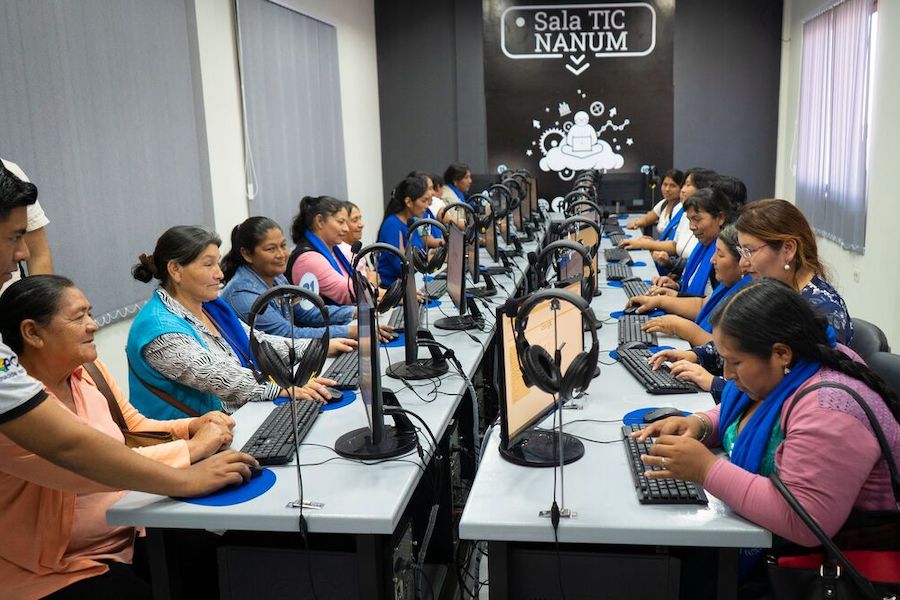 un grupo de mujeres navegando por Internet en una enorme sala de conferencias