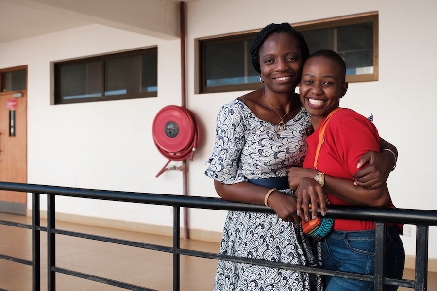 two women at a balcony hugged smiling