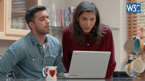 a man and a woman looking at a laptop screen