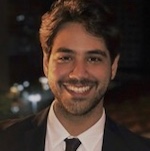 A professional man in a suit and tie smiling confidently at the camera