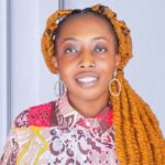 A woman with long braids and a colorful shirt.