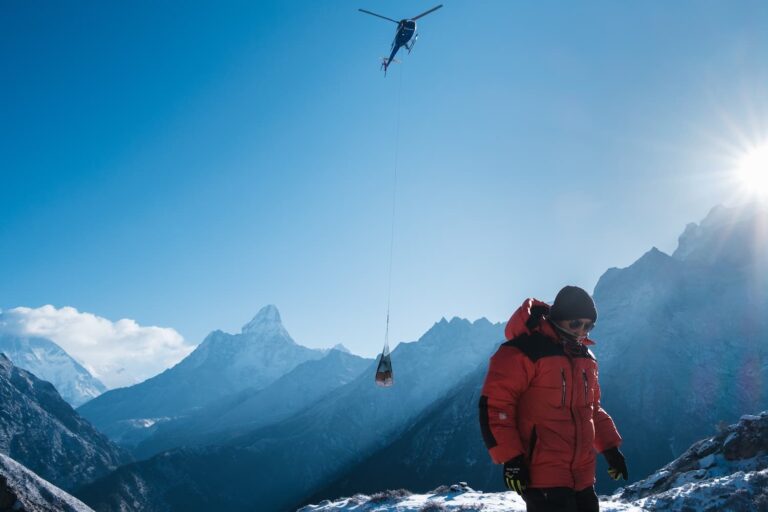 Krishna waiting as a helicopter slinging a load of goods destined for sale in his shop approaches a helipad above the Sherpa village of Khumjung.
