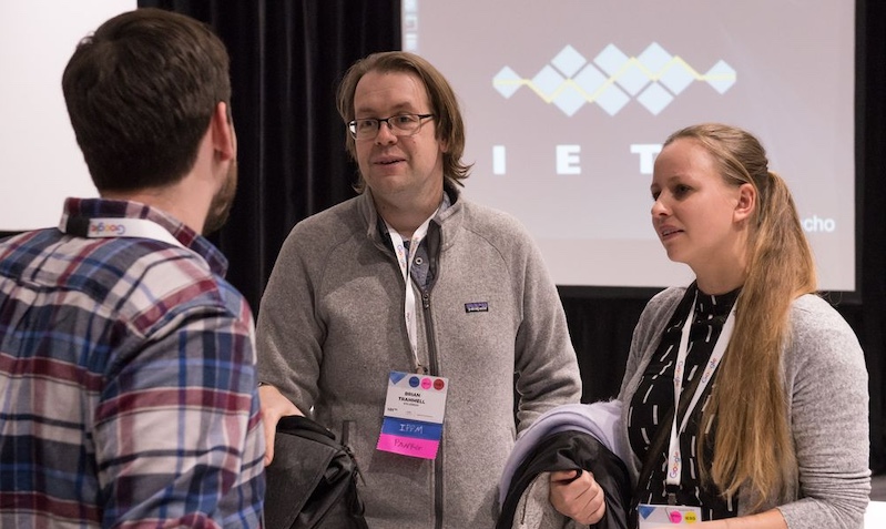 two men and a woman engaged in a discussion