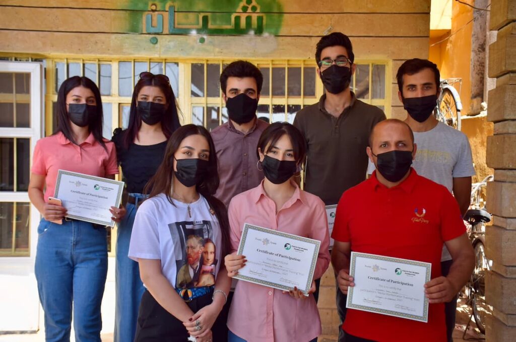 A group photo of people holding certificates of participation from the Youth for Women Foundation