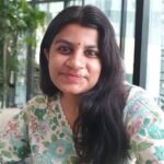 a woman with long dark hair and a colorful shirt