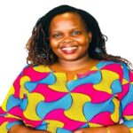 a woman with a long hair wearing a colorful shirt smiling