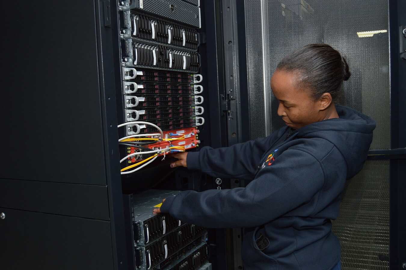 A woman checking IXP equipment