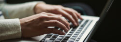Hands type on a computer keyboard