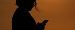 Silhouette of person on their mobile phone