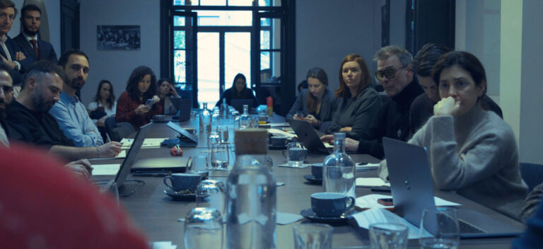 A group of people sit around a table at an encryption workshop in Brussels.