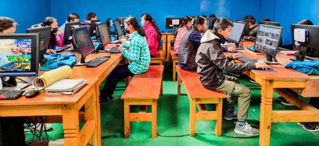 Young people sit and use computers