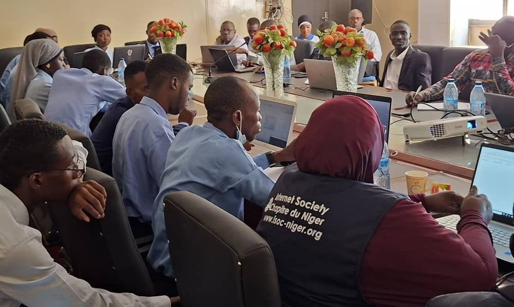 A group of people sit around a table at an Internet Society Niger Chapter event