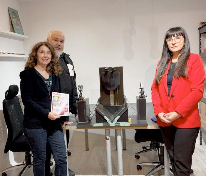 Three people stand at a table