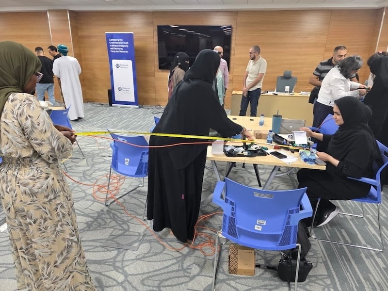Women in hijabs collaborate on a project during a conference